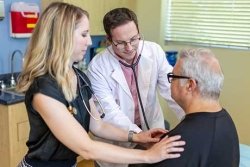 patient being examined with stethoscope.