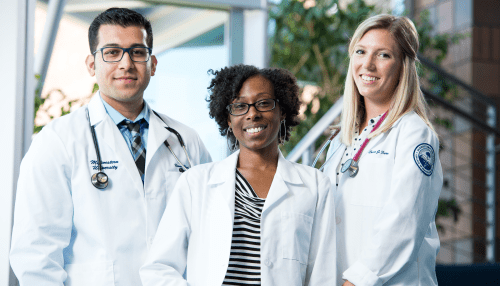 Three healthcare professionals with stethoscopes wearing white coats.