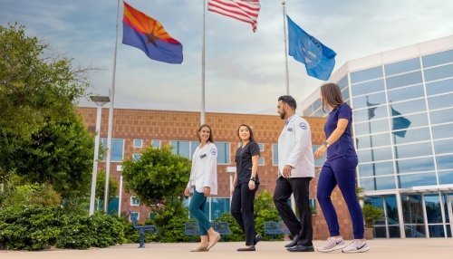 Students walking by flags.