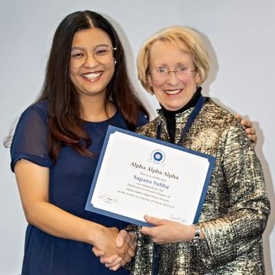 Dr. Goeppinger presents Tri Alpha induction certificate to Sapana Subba.